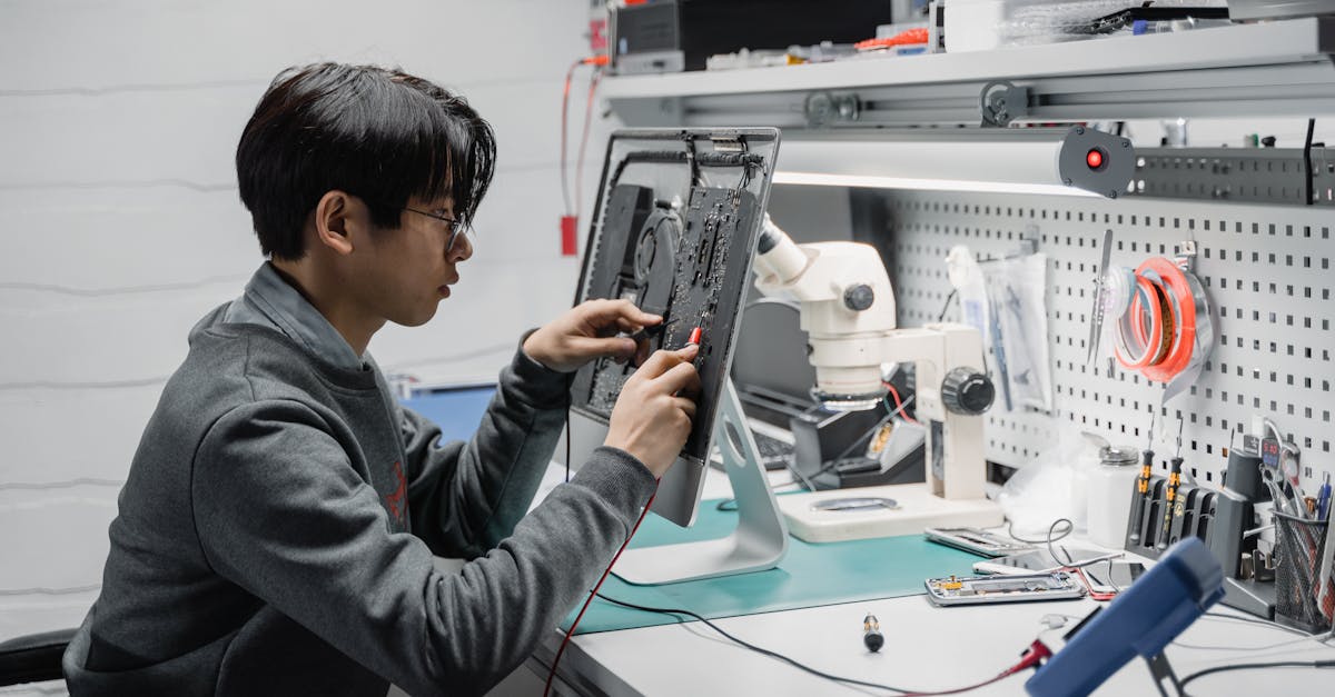 focused young technician working on electronic repairs at a tech lab workspace